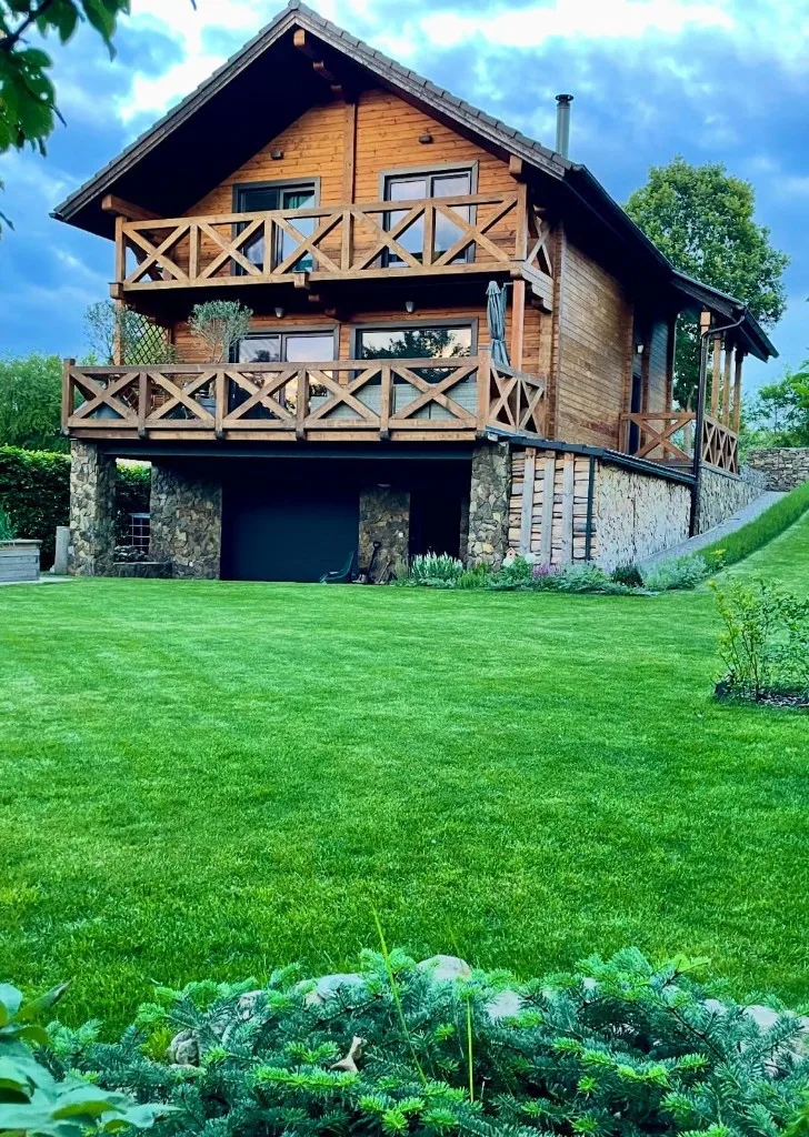 Dřevěná chata se třemi patry v zeleni